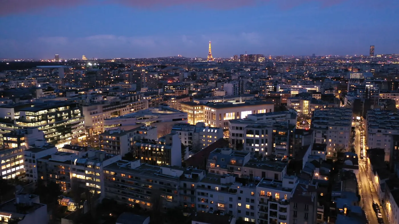 Boulogne-Billancourt au drone à l’heure bleue, tour Eiffel illuminée au loin