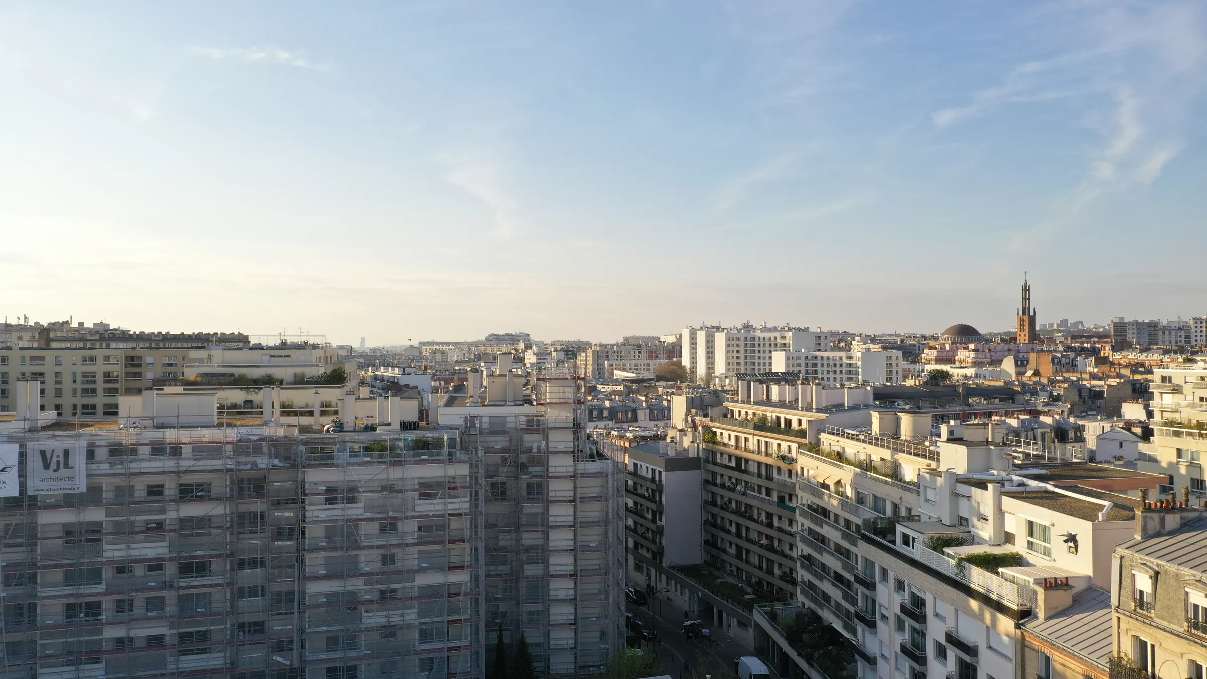Vue depuis une terrasse du 12e arrondissement de Paris, toits et façades haussmanniennes au soleil couchant