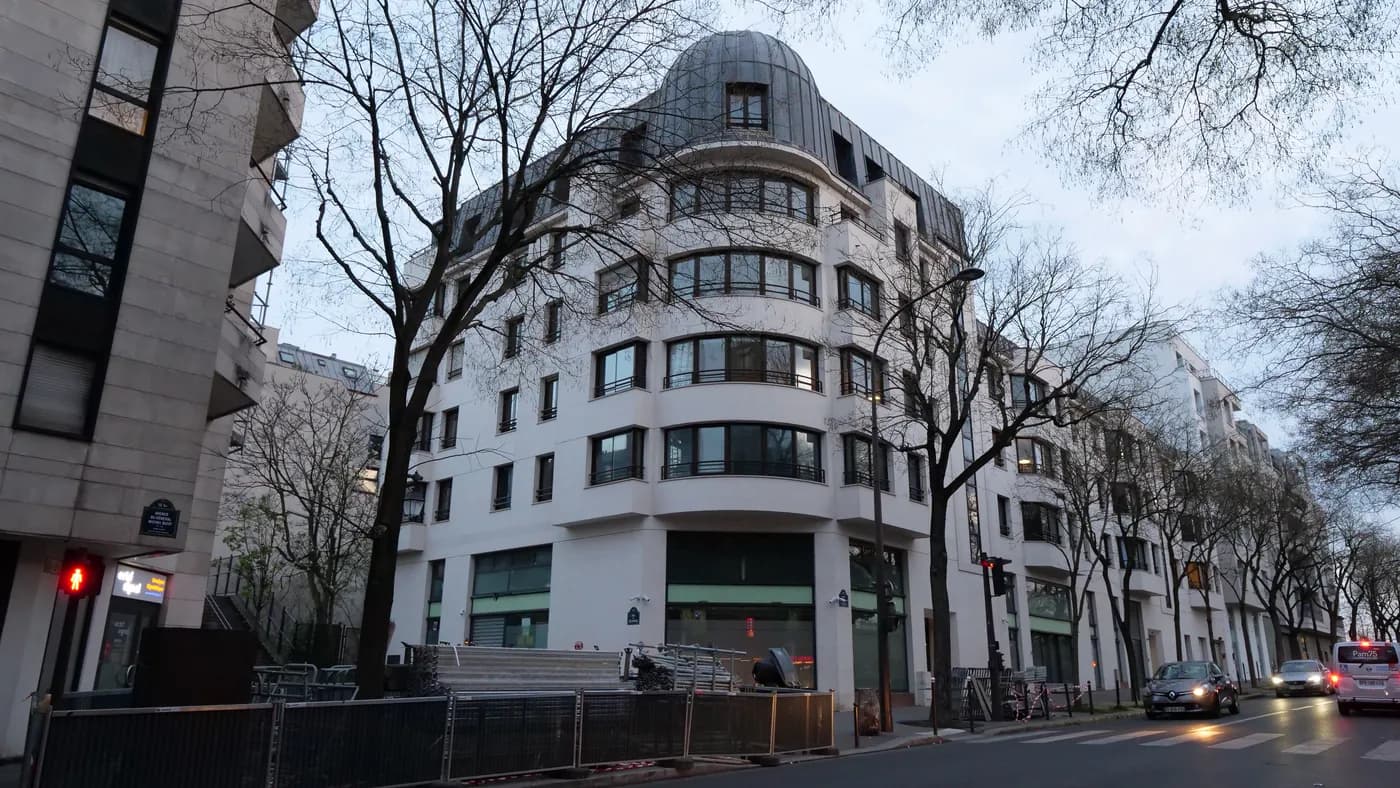 Immeuble neuf à l'angle d'une rue du 12e arrondissement de Paris, à la tombée de la nuit